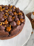 Chocolate tea cake with caramel and nuts on a marble surface