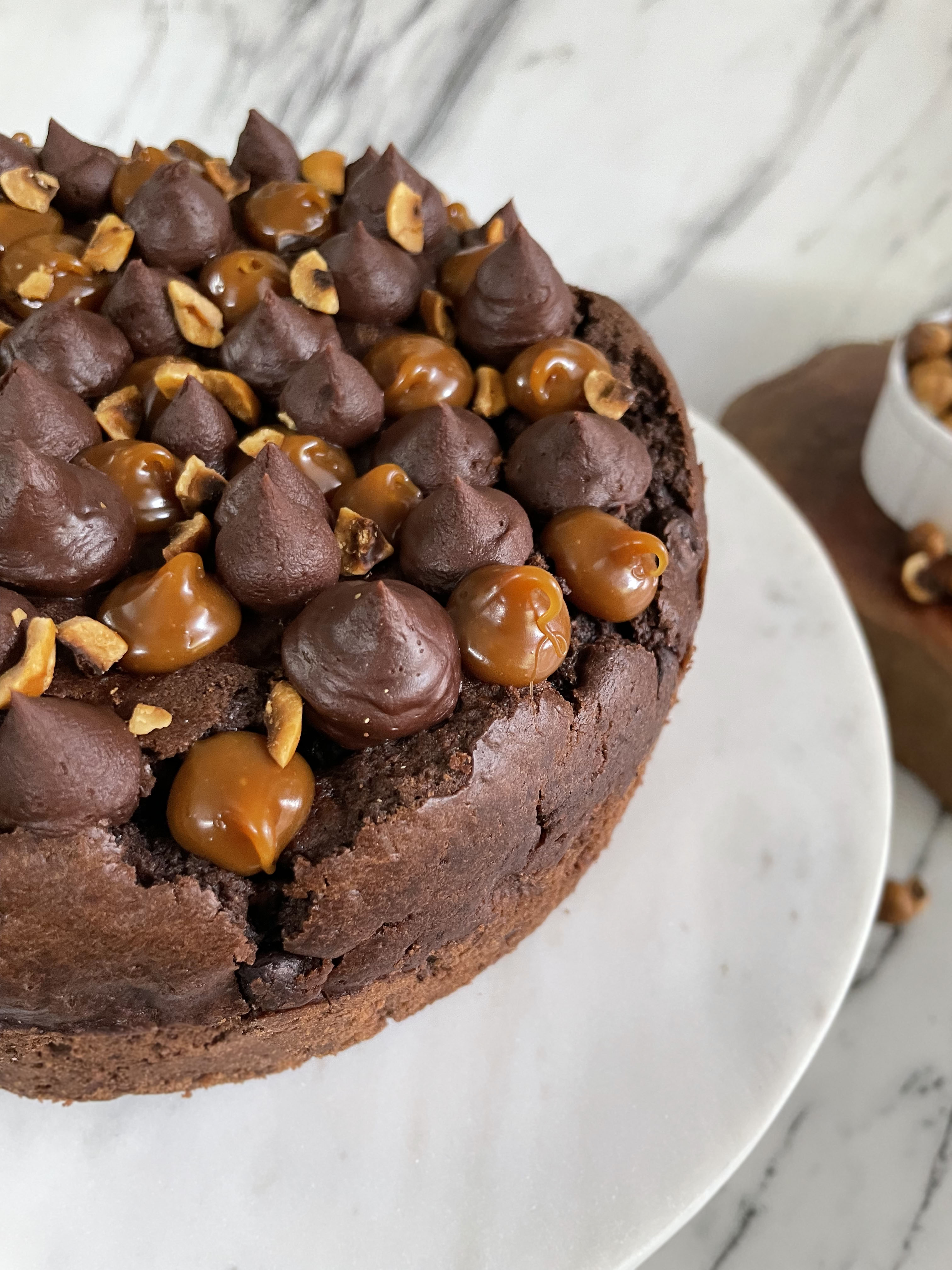 Chocolate tea cake with caramel and nuts on a marble surface