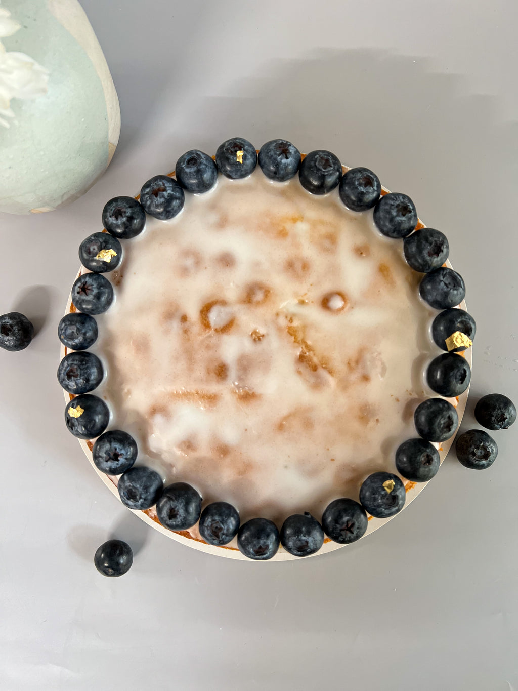 Close-up of a dessert with blueberries and a creamy topping on a light background