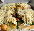 Baked sandwiches with vegetables and cheese on a white plate